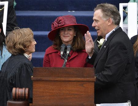 Terry McAuliffe (R) is sworn in as Virginia's governor by Supreme Court Chief Justice Cynthia Kinser (L) as McAuliffe's wife Dorothy witnesses, in Richmond, Virginia, January 11, 2014. REUTERS/Mike Theiler