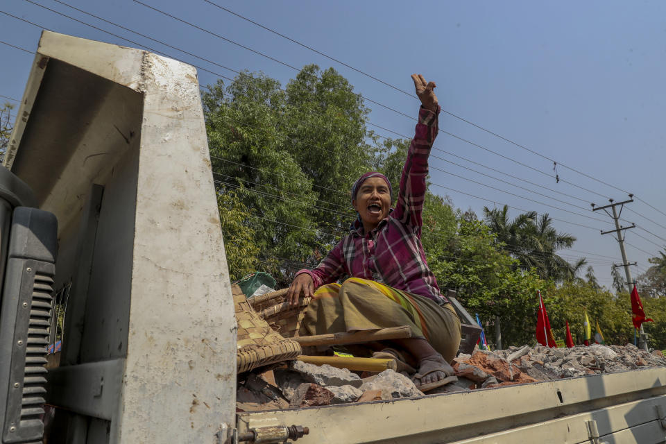 A woman traveling in the back of a truck greets anti-coup protesters with the three-fingered salute in Mandalay, Myanmar, Thursday, Feb. 25, 2021. Social media giant Facebook announced Thursday it was banning all accounts linked to Myanmar's military as well as ads from military-controlled companies in the wake of the army's seizure of power on Feb. 1. (AP Photo)