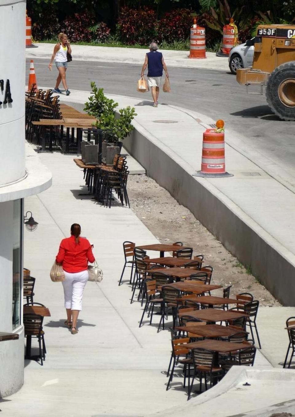 Pedestrians in the Sunset Harbour neighborhood of Miami Beach navigate the newly elevated sidewalks that were built above the original sidewalks. The city of Miami Beach is working on a project to raise the roads and sidewalks in Sunset Harbour as part of its plan to safeguard the city from sea-level rise.