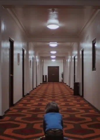 a young boy in the hallway of a hotel in "the shining"