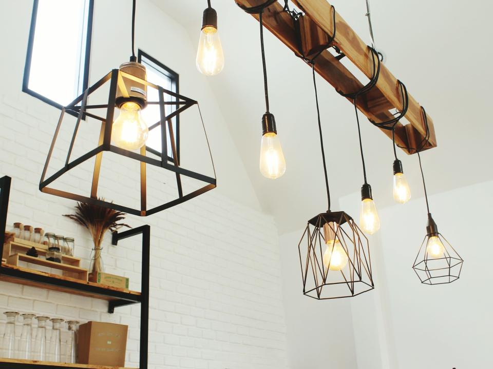 Swag light fixture hanging from wooden beam in white room