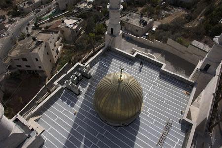 A man walks on the roof of a new mosque in the Israeli-Arab village of Abu Ghosh, near Jerusalem November 22, 2013. REUTERS/Ronen Zvulun