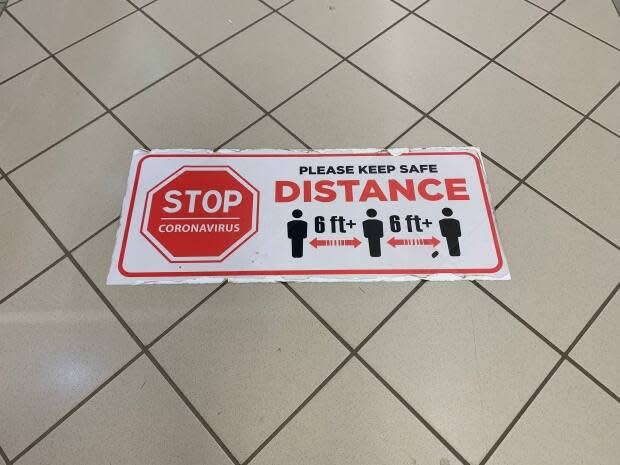 Physical distancing signs are still appearing in some places, including the Confederation Court Mall in Charlottetown. (Shane Ross/CBC - image credit)