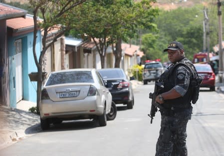 A police officer is seen near a site where an armed gang holds people hostage after they robbed a securities company at the Viracopos airpoart freight terminal, in Campinas