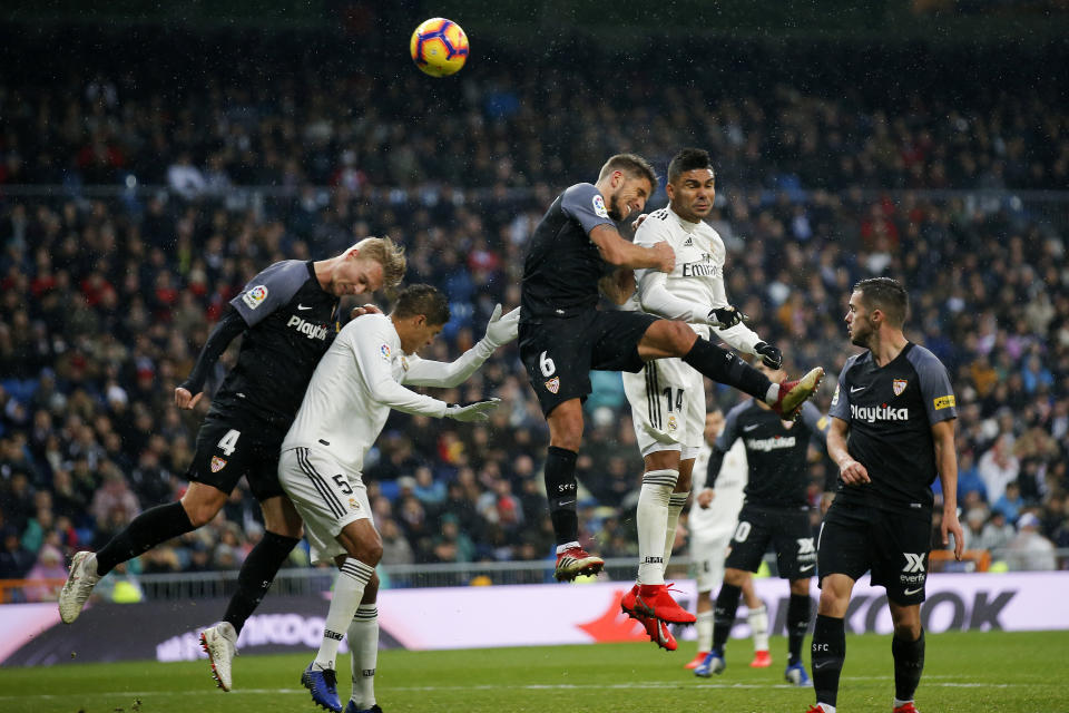 Real Madrid and Sevilla players try to head the ball during the La Liga soccer match between Real Madrid and Sevilla at the Bernabeu stadium in Madrid, Spain, Saturday, Jan. 19, 2019. (AP Photo/Andrea Comas)