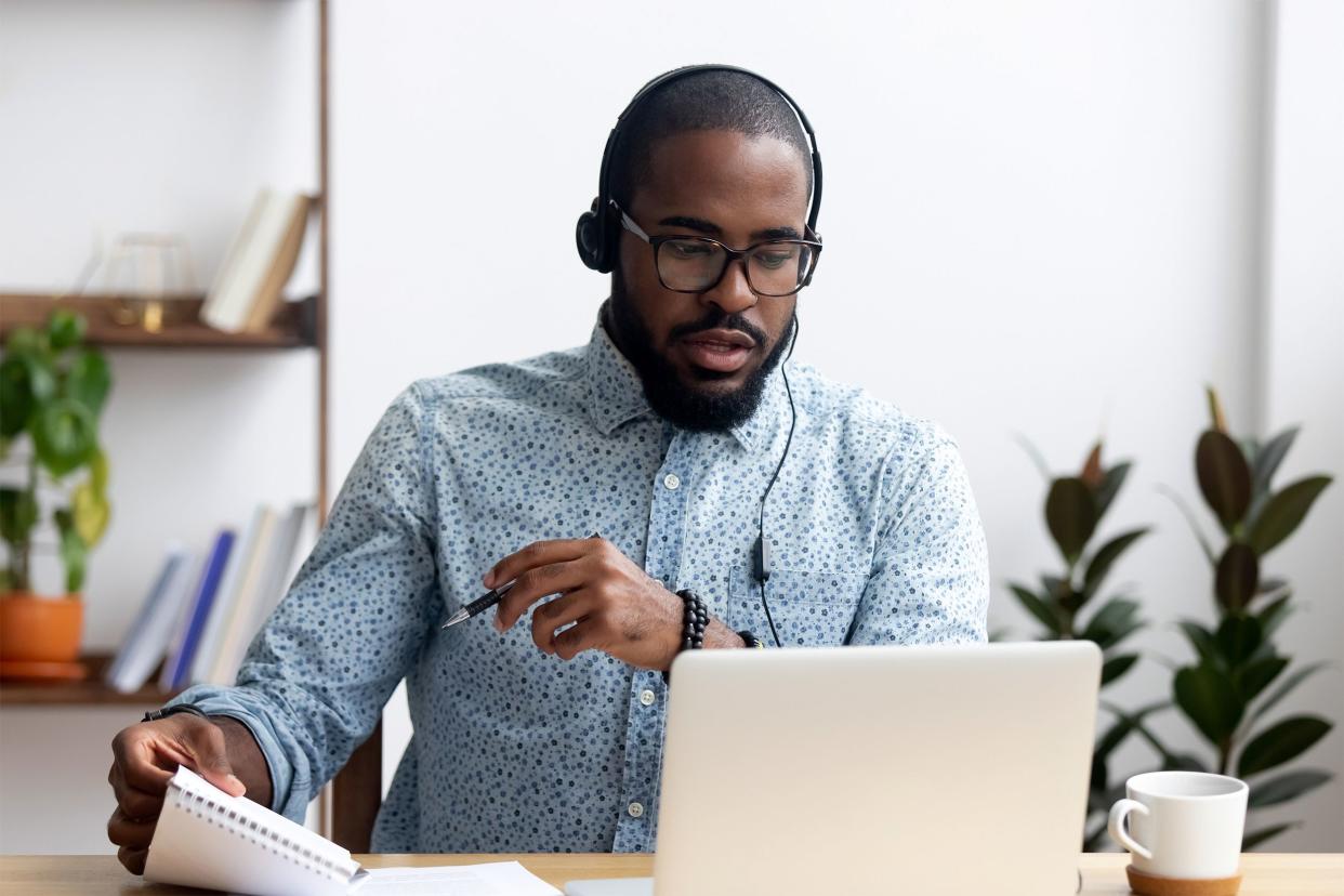 Man wearing headphones and speaking on his laptop