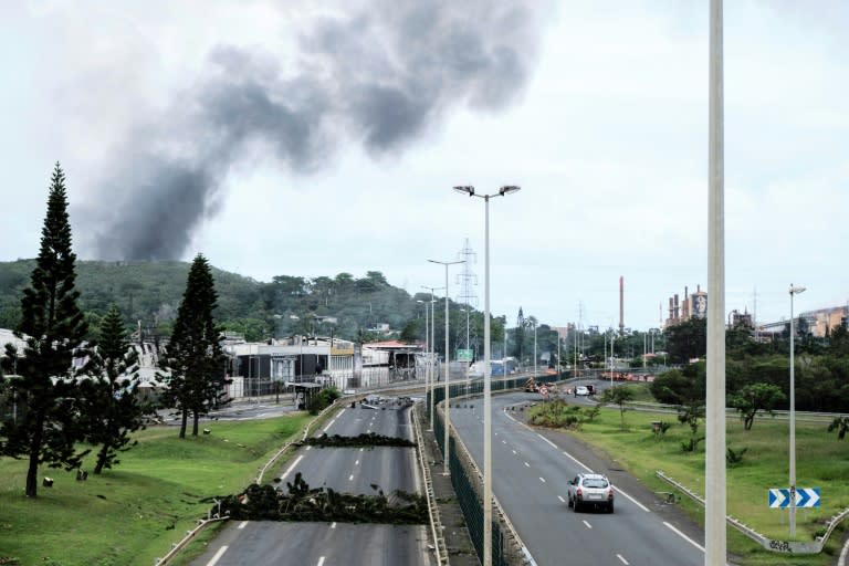 Smoke rises in the distance as roadblocks are seen near the Montravel area of Noumea, capital of France's Pacific territory of New Caledonia (Theo Rouby)