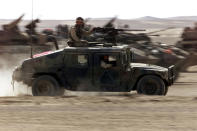 <p>A US Marine Humvee kicks up dust as it crosses a group of Marine LAVs (Light Armoured Vehicles) as it leaves on patrol from the Marine base in southern Afghanistan Dec. 2, 2001. (Photo: Jim Hollander/Reuters) </p>