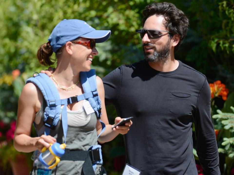 Anne Wojcicki smiles at Sergey Brin while walking outside