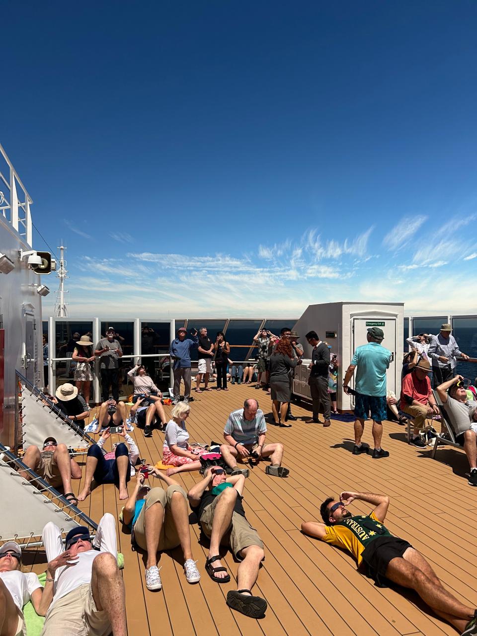 Passengers of Holland America's Koningsdam cruise gathered on the ship's top deck to view the solar eclipse off the coast of Mazatlan, Mexico, on April 8, 2024.