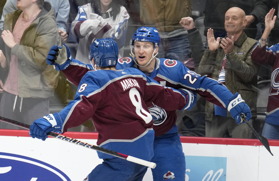 Colorado Avalanche defenseman Cale Makar, front, hugs center Nathan MacKinnon after he scored the go-ahead goal in the third period of an NHL hockey game against the Calgary Flames, Monday, Dec. 11, 2023, in Denver. (AP Photo/David Zalubowski)