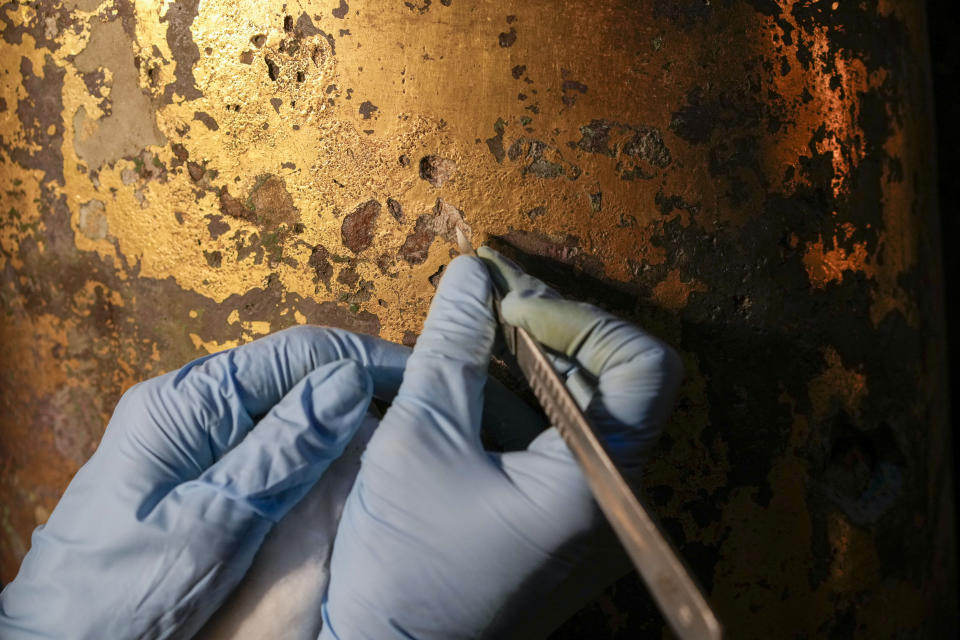 Vatican Museum restorer Chiara Omodei Zorini works on the bronze Hercules statue, in the Round Hall of the Vatican Museums, Thursday, May 11, 2023. Work will continue until December to reveal the 4-meter- (13-foot-) tall Hercules, believed to have stood in ancient Rome’s Pompey Theater, to its original golden sheen. The discovery of the gilded bronze in 1864 during work on a banker’s villa near Piazza dei Fiori made global headlines. (AP Photo/Andrew Medichini)