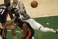 Miami Heat's Trevor Ariza and Milwaukee Bucks' Jrue Holiday go after a loose ball during the first half of an NBA basketball game Saturday, May 15, 2021, in Milwaukee. (AP Photo/Morry Gash)