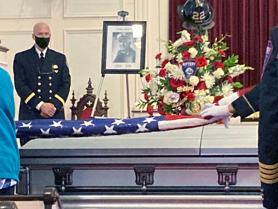 Pastor and firefighter Jeff Pelkey watches as military honors are performe at the funeral of retired Kittery fire chief George Varney Jr. in Eliot Jan. 18, 2022.