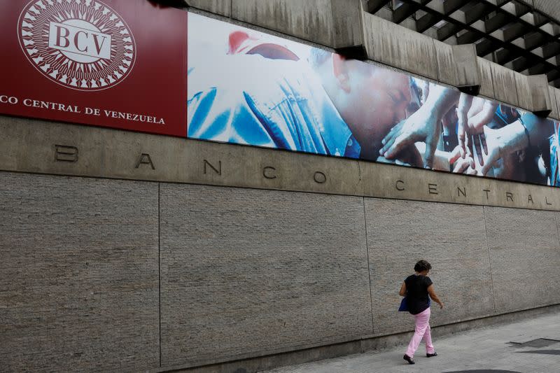 FILE PHOTO: A woman walks outside of the Venezuela's Central Bank in Caracas