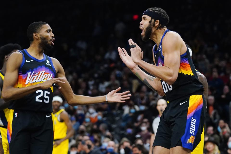 Phoenix Suns center JaVale McGee (00) shouts after being called for a foul as Suns forward Mikal Bridges (25) tries to calm him down during the first half of an NBA basketball game against the Indiana Pacers, Saturday, Jan. 22, 2022, in Phoenix. (AP Photo/Ross D. Franklin)