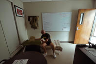 Capt. Michael Switzer prepares to sleep ins office at Camp Beauregard in Pineville, La., Friday, July 30, 2021. (AP Photo/Gerald Herbert)