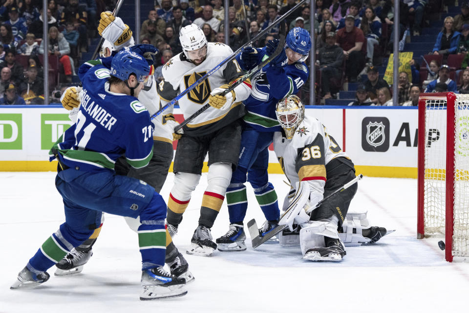 Vancouver Canucks' Brock Boeser, (not shown) scores against Vegas Golden Knights goaltender Logan Thompson (36) as Golden Knights' Nicolas Hague (14), Canucks' Nils Hoglander (21) and Canucks' Elias Pettersson (40) watch during the second period of an NHL hockey game in Vancouver, British Columbia, Monday, April 8, 2024. (Ethan Cairns/The Canadian Press via AP)