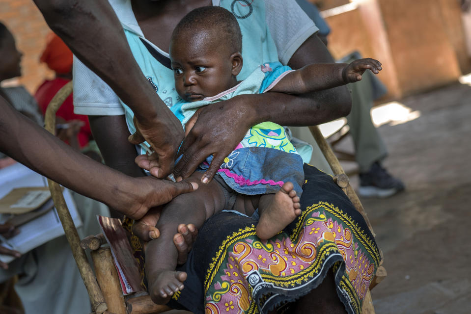 In this photo taken Wednesday, Dec. 11, 2019, health officials vaccine residents of the Malawi village of Tomali, where young children become test subjects for the world's first vaccine against malaria. Babies in three African nations are getting the first and only vaccine for malaria in a pilot program. World health officials want to see how well the vaccine works in Malawi, Ghana and Kenya before recommending its wider use. (AP Photo/Jerome Delay)