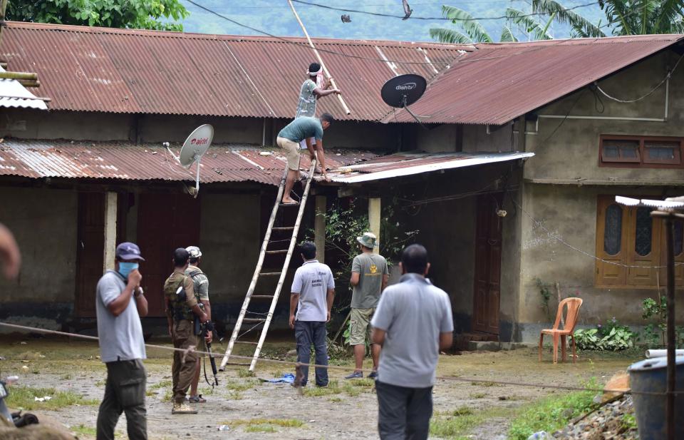 Forest official try to rescued a tigress which strayed into a house in Baghmari area at Bagori range being rescued in Nagaon District of Assam. (Photo credit should read Anuwar Ali Hazarika/Barcroft Media via Getty Images)