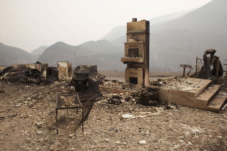 The remains of a home burnt by the Chelan Complex Fire are seen in Chelan, Washington, August 17, 2015. REUTERS/David Ryder