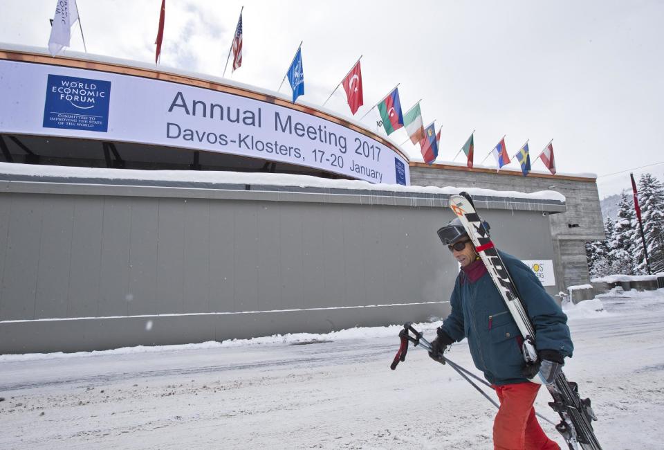 A man walks past the congress center with his skies where the annual meeting, World Economic Forum, will take place in Davos, Switzerland, Sunday Jan. 15, 2017. Business and world leaders are gathering for the annual meeting in Davos. (AP Photo/Michel Euler)