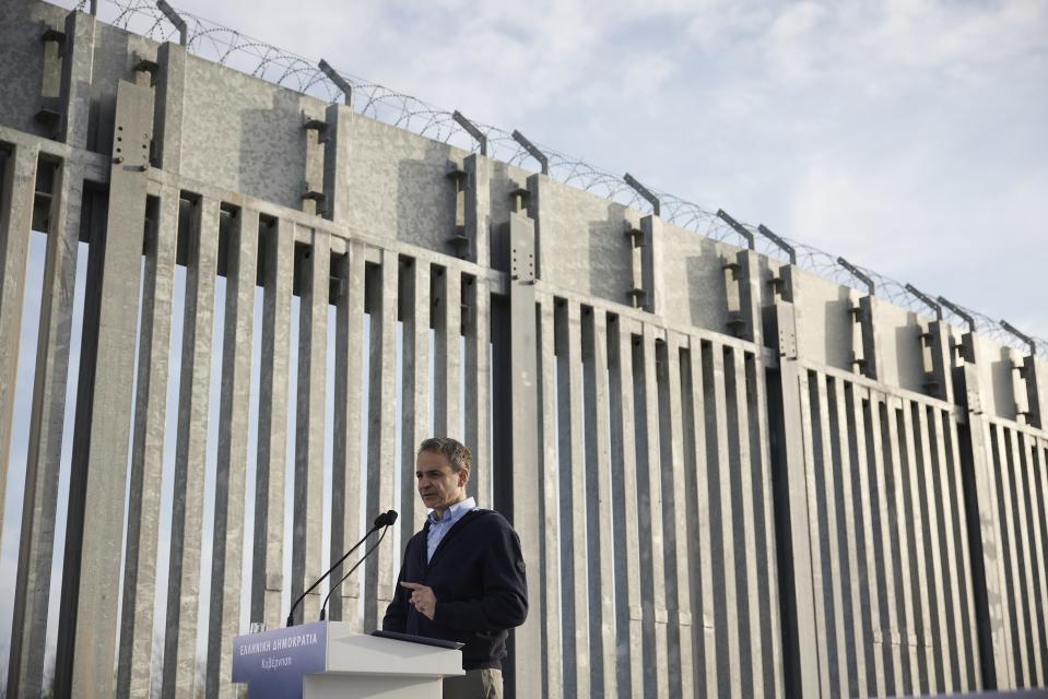 In this photo provided by the Greek Prime Minister's Office, Greece's Prime Minister Kyriakos Mitsotakis delivers a speech next to a border wall near the town of Feres, along the Evros River which forms the frontier between Greece and Turkey, Friday, March 31, 2023. Mitsotakis promised Friday to extend a wall across all of the country's land border with Turkey as he campaigned for the country's general election. (Dimitris Papamitsos/Greek Prime Minister's Office via AP)