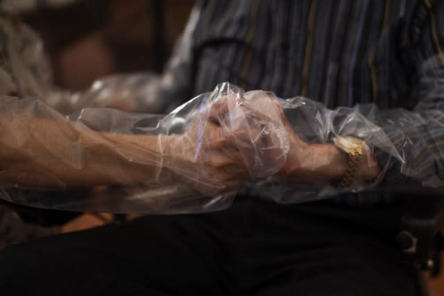 Holding hands through plastic sheeting