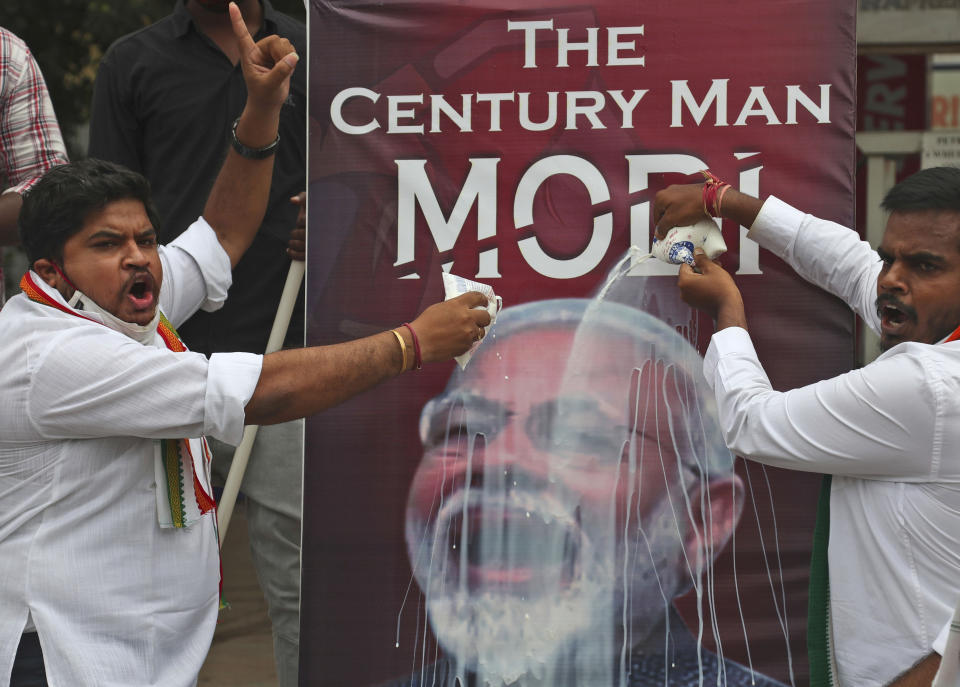 FILE - In this Friday, June 11, 2021 file photo, activists of India's opposition Congress party pour milk over a poster of Indian Prime Minister Narendra Modi, to mockingly celebrate fuel price reaching the century mark, during a protest against the hike of petrol and diesel price in Hyderabad, India. The coronavirus pandemic has upended life around the globe, but it has hasn’t stopped the spread of authoritarianism and extremism. Some researchers believe it may even have accelerated it, but curbing individual freedoms and boosting the reach of the state. Since COVID-19 hit, Hungary has banned children from being told about homosexuality. China shut Hong Kong’s last pro-democracy newspaper. Brazil’s president has extolled dictatorship. Belarus has hijacked a passenger plane. A Cambodian human rights lawyer calls the pandemic “a dictator's dream opportunity.” But there are also resistance movements, as protesters from Hungary to Brazil take to the streets to defend democracy. (AP Photo/Mahesh Kumar A, File)