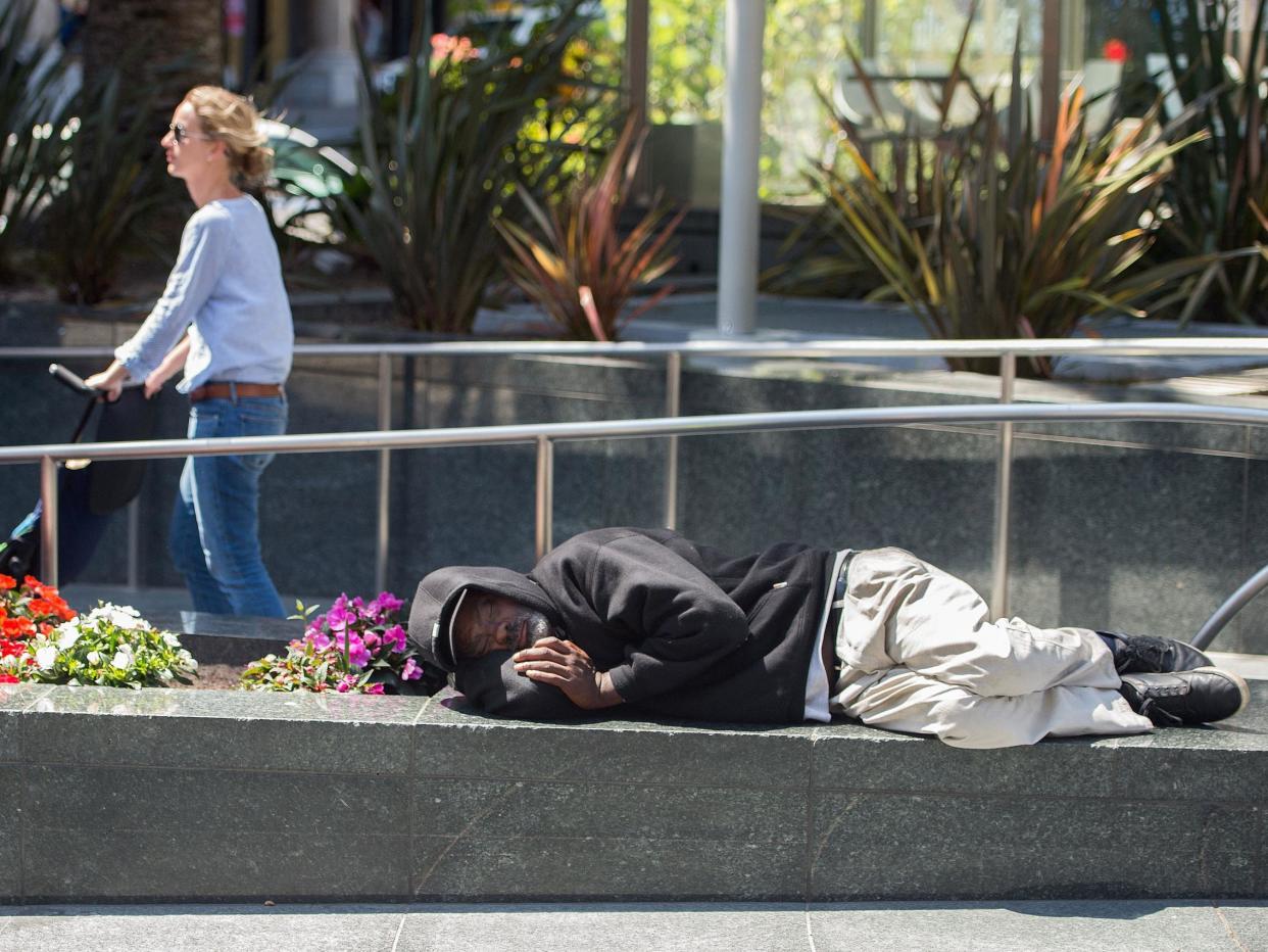 A homeless man sleeps in San Francisco, where more than 7,000 people have nowhere to live: AFP/Getty