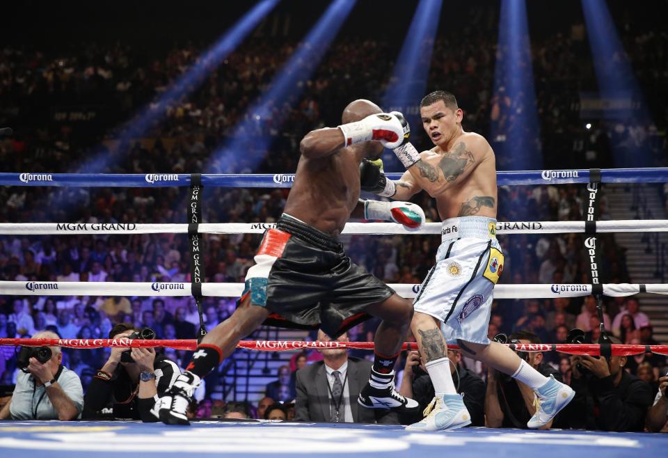 Floyd Mayweather Jr., left, trades blows with Marcos Maidana, from Argentina, in their WBC-WBA welterweight title boxing fight Saturday, May 3, 2014, in Las Vegas. (AP Photo/Eric Jamison)
