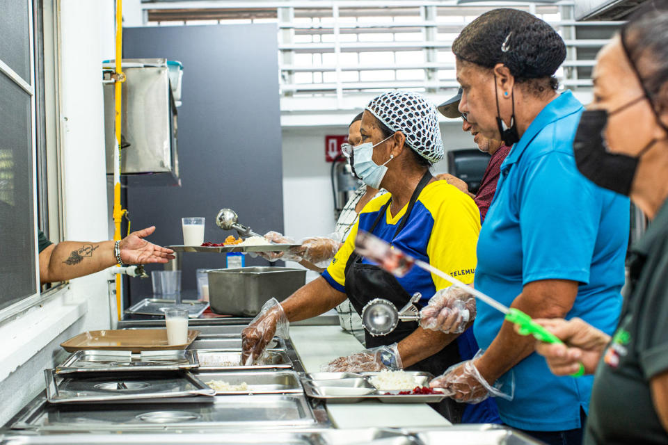 Workers serve lunch at the Center for Activities and Multiple Uses for the Elderly of Toa Baja in Toa Baja, Puerto Rico, on May 26, 2023. (Erika P. Rodríguez for NBC News)