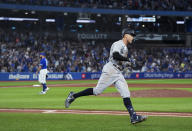 New York Yankees' Aaron Judge runs the bases after hitting his 61st home run of the season, off Toronto Blue Jays relief pitcher Tim Mayza, left, during the seventh inning of a baseball game Wednesday, Sept. 28, 2022, in Toronto. (Nathan Denette/The Canadian Press via AP)