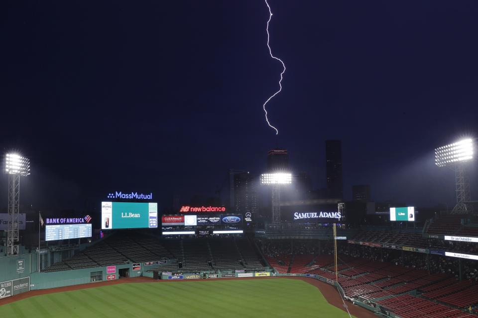 Lightning strikes the Prudential Tower beyond Fenway Park during a rain delay before a baseball game between the Boston Red Sox and the <a class="link " href="https://sports.yahoo.com/mlb/teams/tampa-bay/" data-i13n="sec:content-canvas;subsec:anchor_text;elm:context_link" data-ylk="slk:Tampa Bay Rays;sec:content-canvas;subsec:anchor_text;elm:context_link;itc:0">Tampa Bay Rays</a>, Friday, June 2, 2023, in Boston. The game was postponed. (AP Photo/Michael Dwyer)