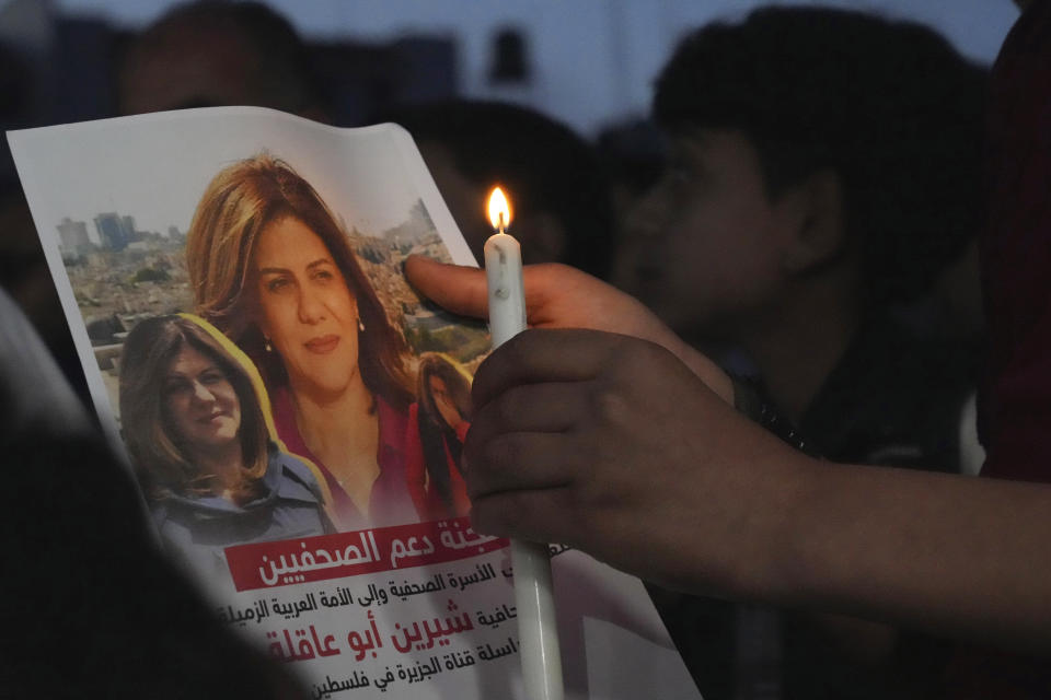 FILE - A Palestinian holds a picture of slain Palestinian-American Al Jazeera journalist Shireen Abu Akleh, during a candlelight event to condemn her killing, in front of the office of Al Jazeera network, in Gaza City, May 11, 2022. At least 85 Palestinians have been killed in the West Bank this year as Israeli forces have carried out nightly raids in cities, towns and villages, making it the deadliest in the occupied territory since 2016. (AP Photo/Adel Hana, File)