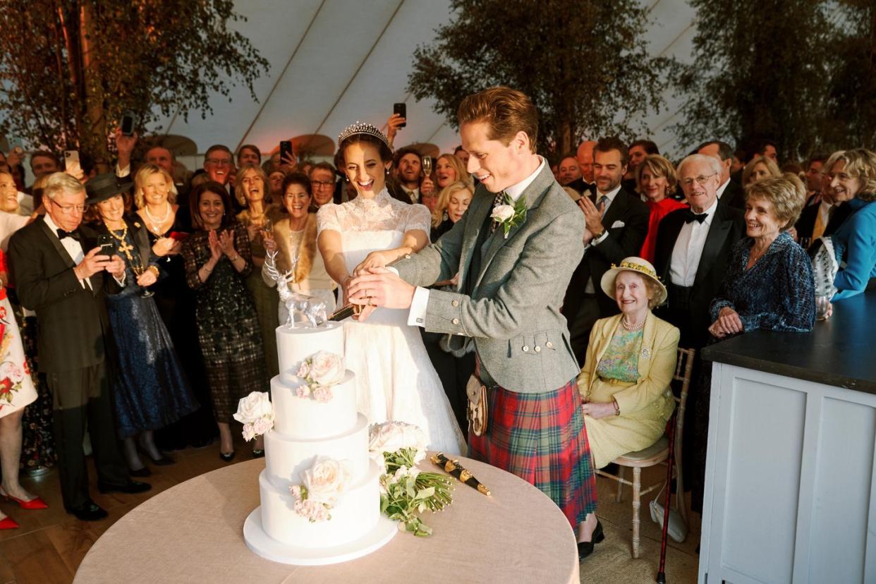 a bride and groom cutting their wedding cake