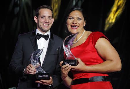 Shot putter Valerie Adams of New Zealand (R) poses with World-record pole vaulter Renaud Lavillenie of France (L) after receiving their 2014 IAAF Athletes of the Year trophies during the IAAF Gala in Monte Carlo November 21, 2014. REUTERS/Eric Gaillard