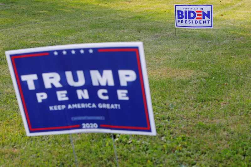 Campaign signs for Trump and Biden stand along a road in Lower Saucon Township