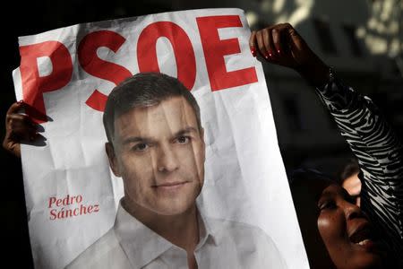 A supporter of Spain's Socialist party (PSOE) leader Pedro Sanchez holds his poster outside the party's headquarters during the party's assembly meeting in Madrid, Spain, October 1, 2016. REUTERS/Susana Vera