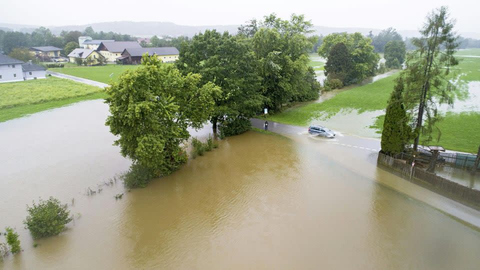 A car drives on a flooded street in Braunau am Inn, Austria. - Manfred Fesl/APA/AFP/Getty Images