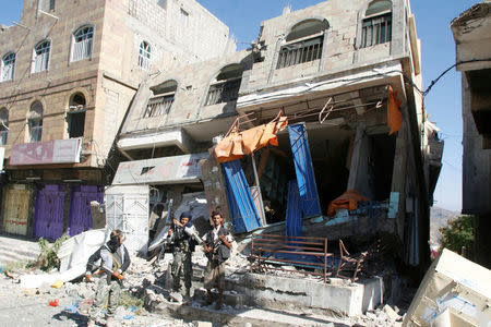 Pro-government fighters stand in front of a damaged building in the southwestern city of Taiz, Yemen November 21, 2016. REUTERS/Anees Mahyoub