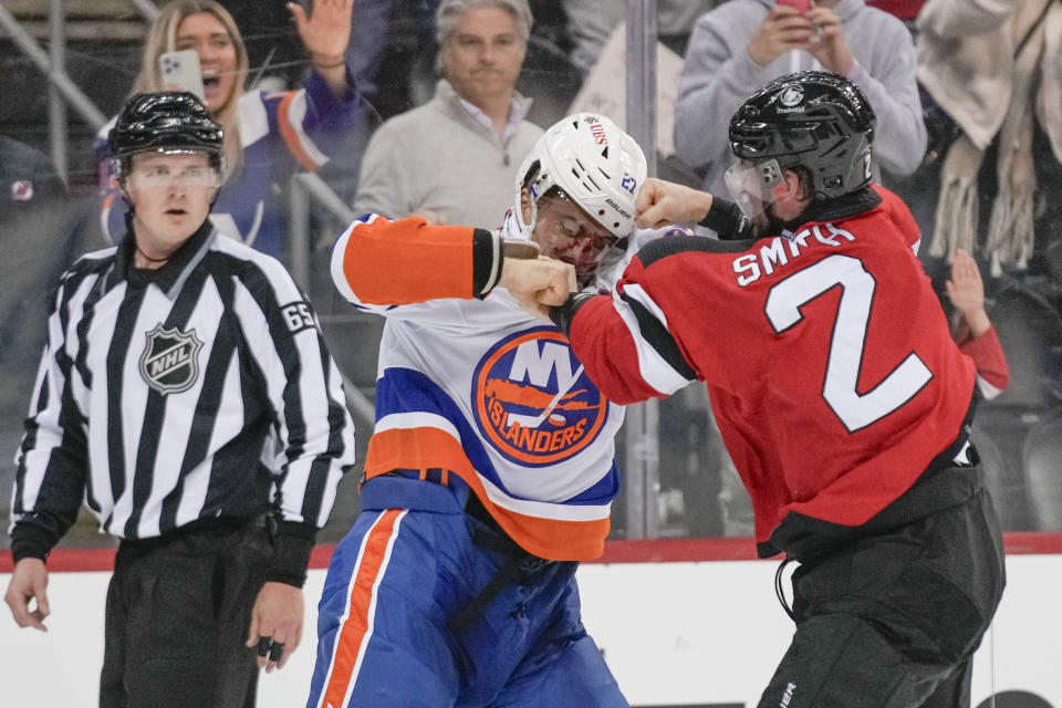 New Jersey Devils' Brendan Smith, right, fights with New York Islanders' Anders Lee during the third period of an NHL hockey game in Newark, N.J., Tuesday, Nov. 28, 2023. The Devils defeated the Islanders 5-4. (AP Photo/Seth Wenig)