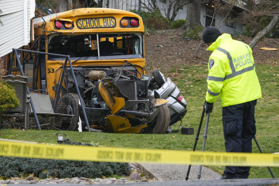 A school bus involved in an accident is seen in New Hempstead, N.Y., Thursday, Dec. 1, 2022. Multiple injuries were reported Thursday when a school bus crashed into a house and another vehicle in a suburb north of New York City. (AP Photo/Seth Wenig)