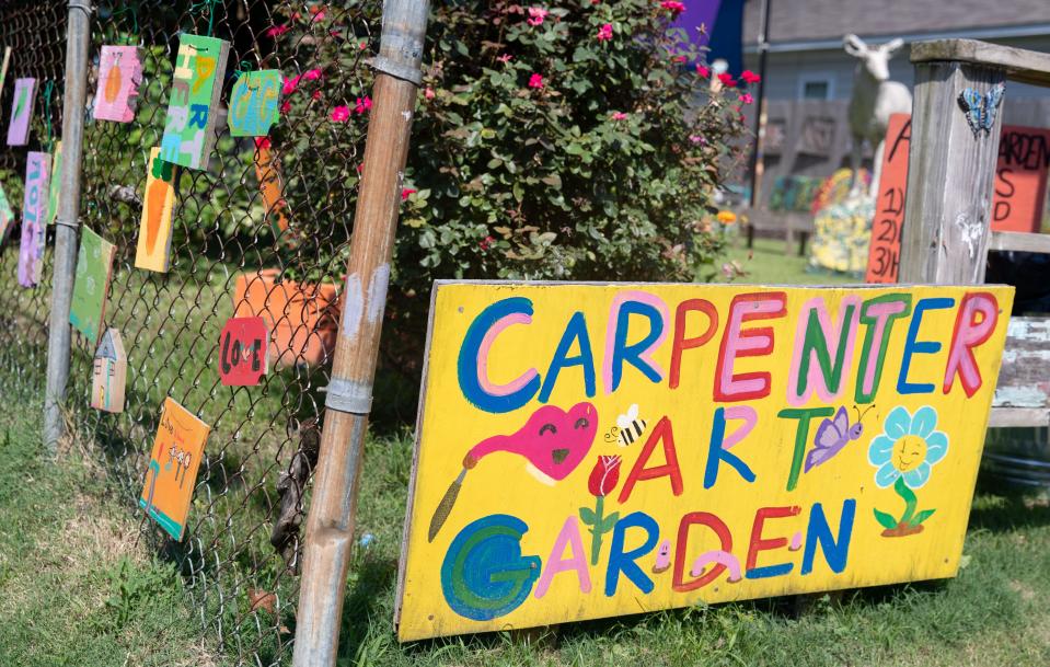 A sign sits at the entrance of Carpenter Art Garden on Thursday, Aug. 18, 2022, in the Binghampton neighborhood in Memphis. Carpenter Art Garden is a non-profit that provides after-school activities and classes, including sewing and cooking classes, to community members. 