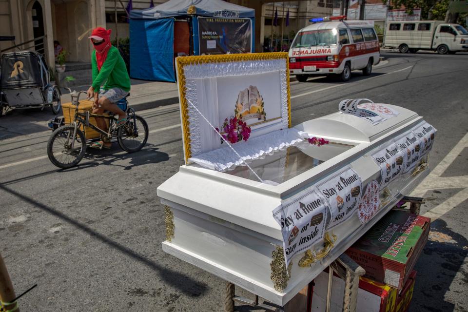 A coffin is seen in the middle of a road warning residents to stay home amid the threat of the coronavirus on March 26, 2020 in Santo Tomas, Pampanga province, Philippines.