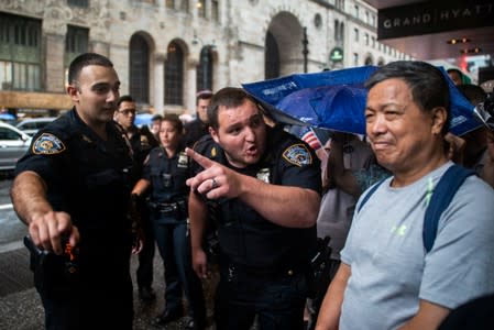 Police officers talk with a demonstrator as people gather outside Grand Hyatt hotel, where Taiwan's President Tsai Ing-wen is supposed to stay during her visit to the U.S., in New York City