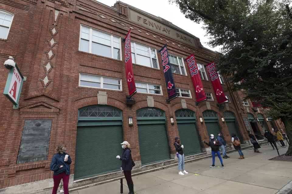 People wait in line for early voting to open at Fenway Park, Saturday, Oct. 17, 2020, in Boston. (AP Photo/Michael Dwyer)