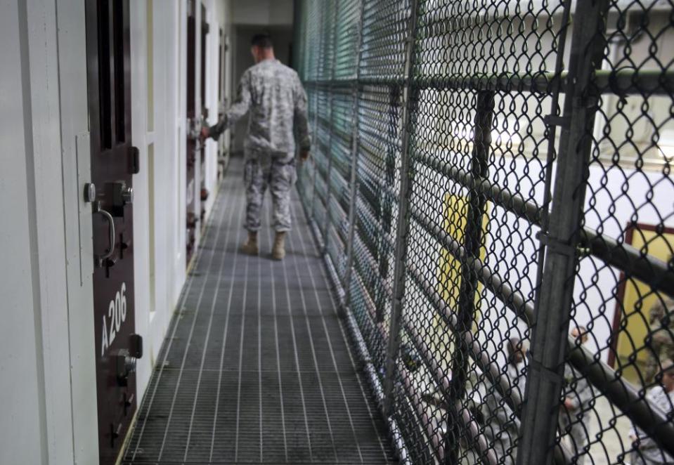 A US army captain walks past an unoccupied detainee cell at Camp 6 of the detention center at Guantánamo Bay. At its peak in 2003, the facility held nearly 680 prisoners; there are now 39 prisoners left.
