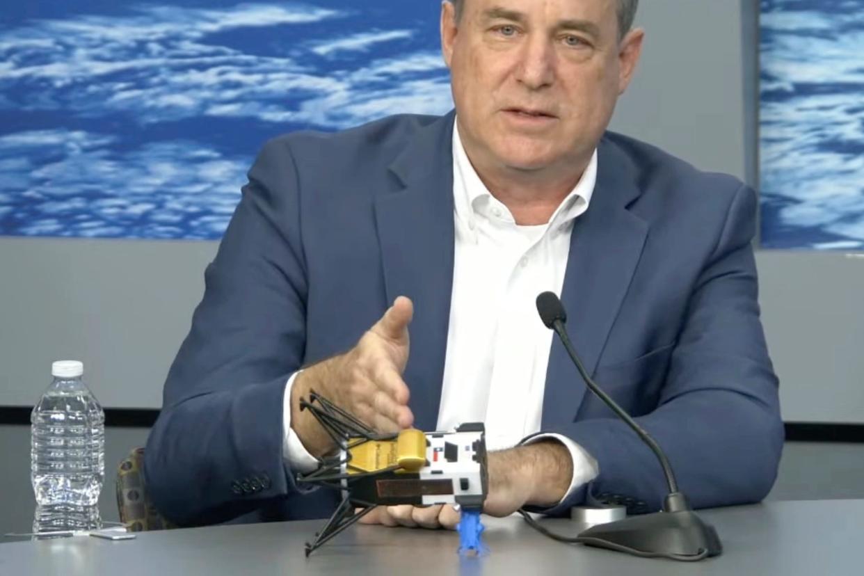 Steve Altemus, CEO and co-founder of Intuitive Machines, presents a model of Odysseus tipped on its side in the position the company believes it landed on the surface of the moon Thursday. The first American spaceship on the moon since Apollo likely face-planted into the dirt after catching on a rock during its landing, the company said Friday.