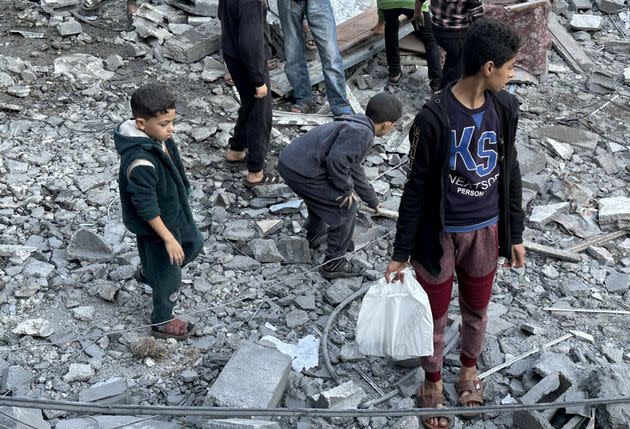 Residents and civil defense teams conduct a search-and-rescue operation Wednesday amid the rubble of a building that collapsed following an Israeli attack on houses belonging to the Abu Hubeyze and Abu Ayesha families at the Nuseirat refugee camp in Deir al-Balah, Gaza.